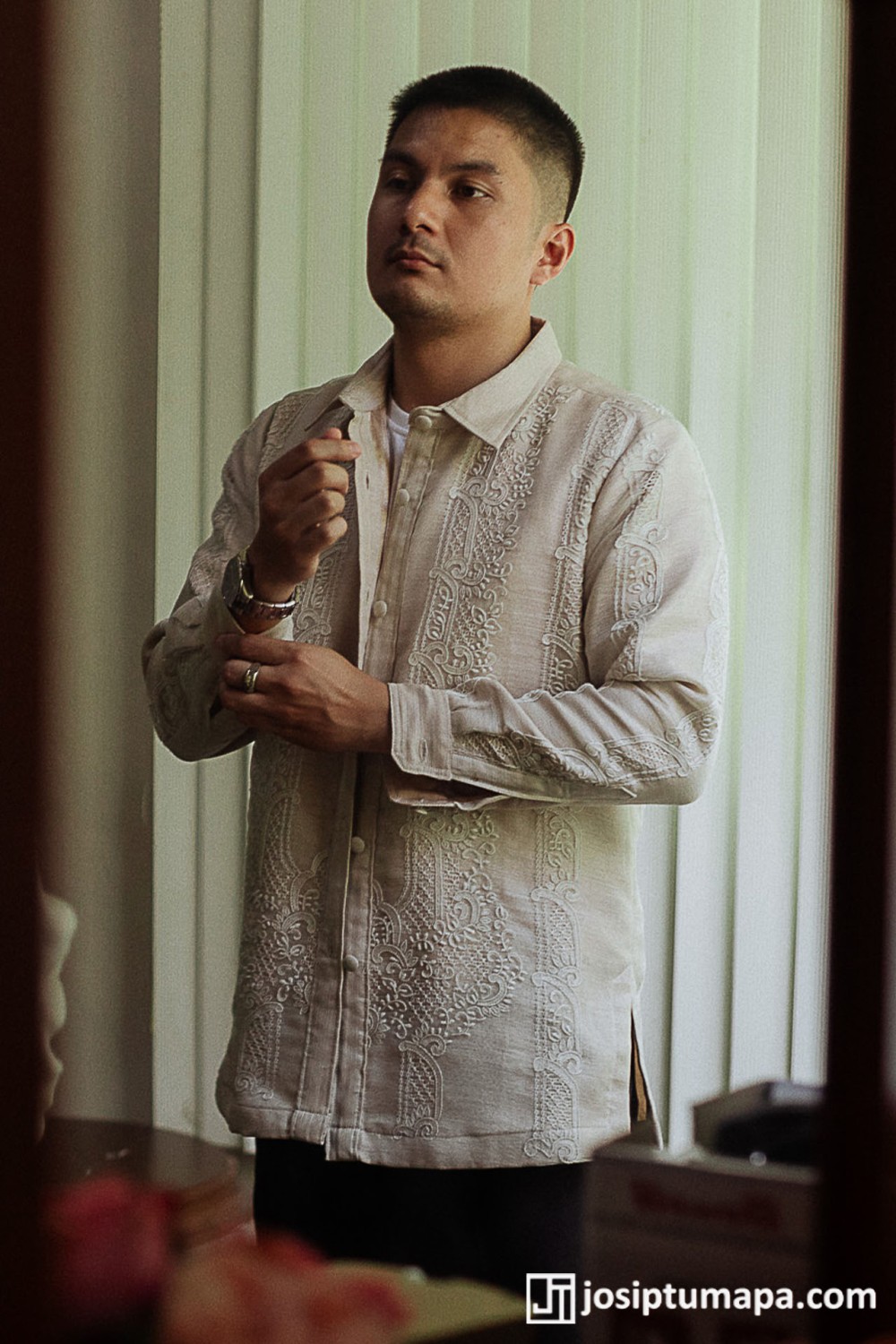 Groom wearing an ivory custom wedding Barong Tagalog with dense hand embroidery across the front, shoulders, sleeves, and cuffs.