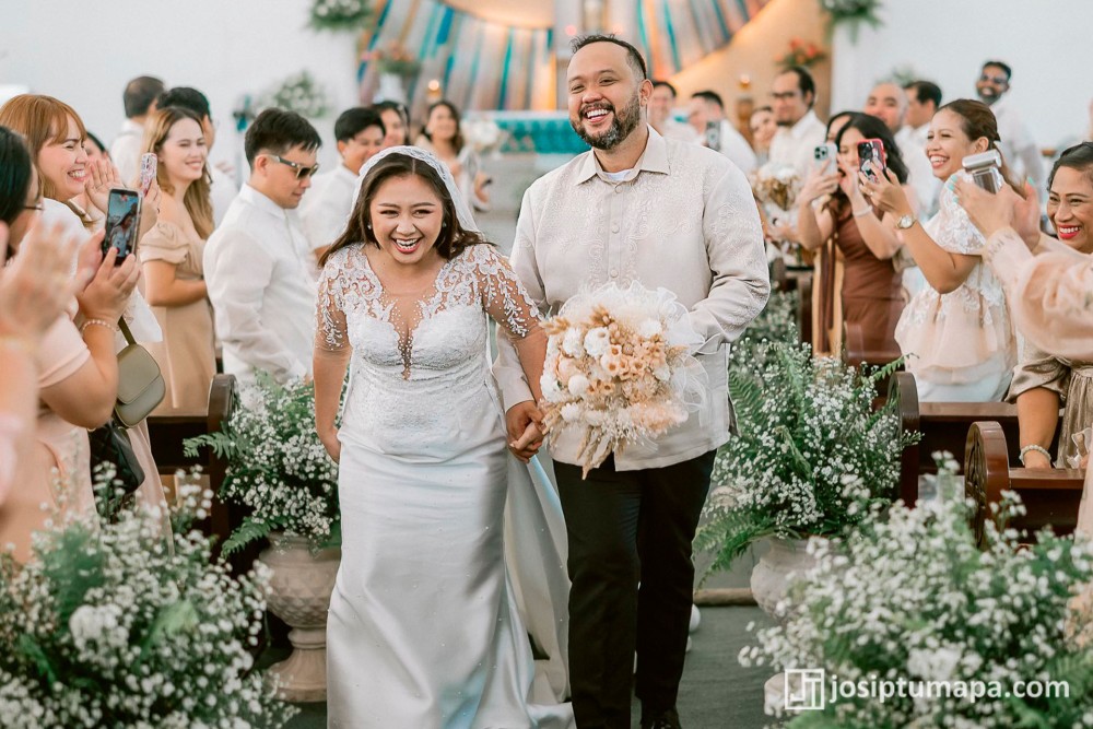 Groom wearing a wedding Barong Tagalog with embroidered ornament extending across the front and sleeves during the ceremony